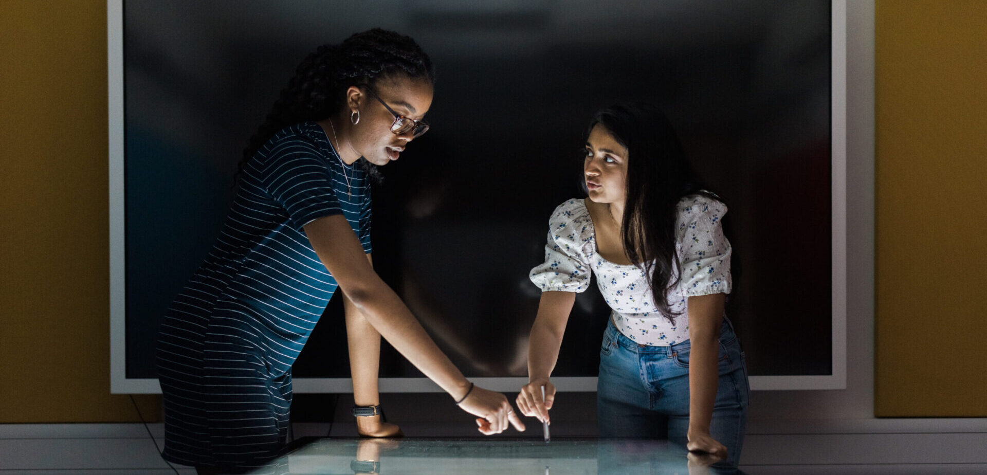 Two student founders using the touch screen table